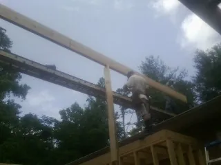 Carpenter setting a ridge beam over a new addition frame — Ice Dam Removal by Roofing Brothers in Wabash