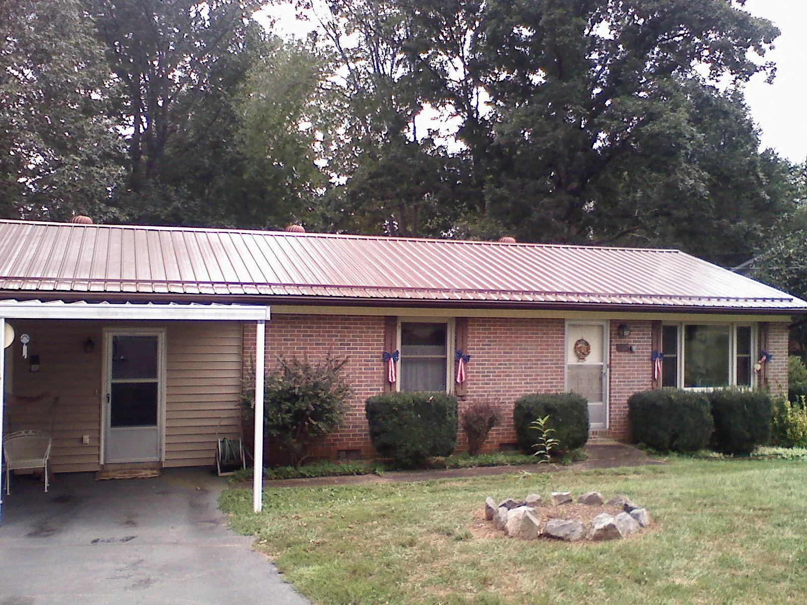 Bronze metal roof and carport on a brick ranch home — Roof Repair work by our crew in Wabash